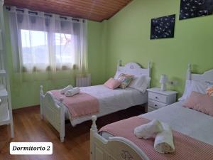 two beds in a room with green walls at Ultreia in Arcade
