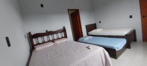 a room with two beds in a room at Área de Lazer Portal da Canastra in Delfinópolis +12 photos