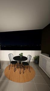 a black table and two chairs in a room at Cozy Suite in Schofields in Schofields +2 photos