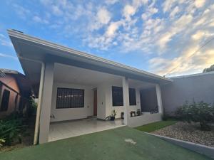 a white house with a patio in the yard at Casa Burbujas in Puerto Jiménez +7 photos
