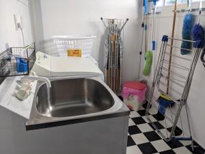 a kitchen with a sink and a checkered floor at Charming homely Cherry Villa B&B with a panorama view in Paraparaumu