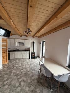 a kitchen with a table and chairs in a room at Domek pod Besidą in Czarna