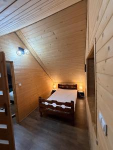 a bedroom with a bed in a wooden cabin at Domek pod Besidą in Czarna