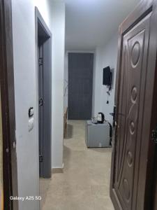 a hallway with a door and a room with a television at Hayat Pyramids House DBL 59S in ‘Ezbet `Abd el-Ḥamîd