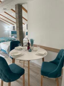a dining room with a white table and blue chairs at Yugoslavija Lux 3 in Aleksandrovac