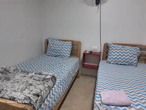 two beds sitting next to each other in a room at Hayat Pyramids House DBL 59S in ‘Ezbet `Abd el-Ḥamîd