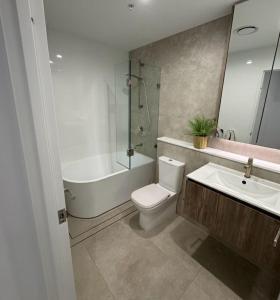 a bathroom with a toilet and a sink and a shower at Cozy Suite in Schofields in Schofields