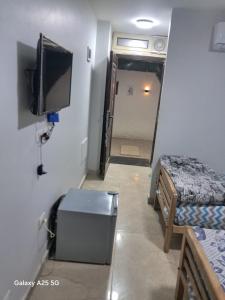 a room with two beds and a flat screen tv at Hayat Pyramids House DBL 59S in ‘Ezbet `Abd el-Ḥamîd