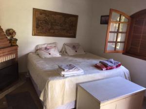 a bedroom with a bed with two towels on it at Sítio frente à Barragem in Salesópolis