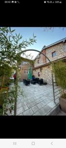 a courtyard with a stone building with a patio at Yugoslavija Lux 3 in Aleksandrovac