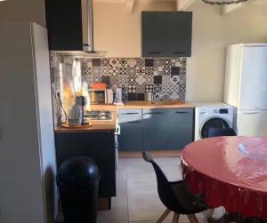 a kitchen with a table and a table and a kitchen with a tableablish at Gîte Ruoms in Ruoms