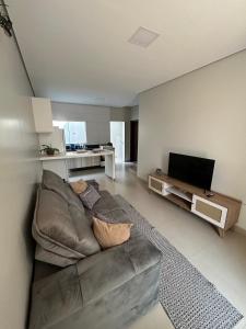 a living room with a couch and a flat screen tv at Apartamento Centro 02 in Vilhena