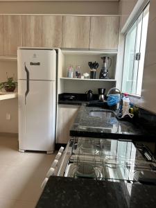 a kitchen with a white refrigerator and a sink at Apartamento Centro 02 in Vilhena +6 photos