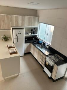 a kitchen with a white refrigerator and a sink at Apartamento Centro 02 in Vilhena