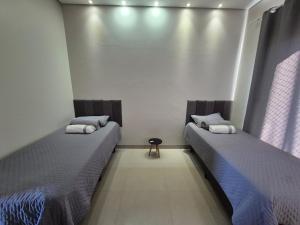 two beds sitting in a room withermottermottermott at Apartamento Centro 02 in Vilhena