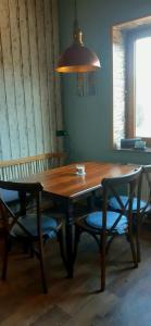 a wooden table with two chairs and a lamp at Haus am Bach in Miehlen