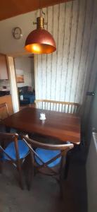 a wooden table with two chairs and a lamp at Haus am Bach in Miehlen