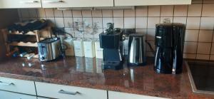 a kitchen counter with several coffeemakers on it at Haus am Bach in Miehlen