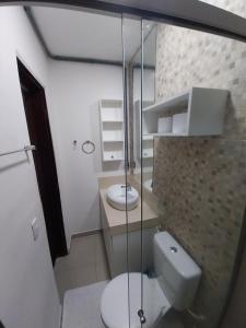 a bathroom with a toilet and a glass shower at Pousada Dunas Natal in Natal