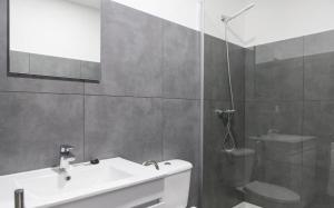 a bathroom with a white sink and a shower at Porto República Suites in Porto