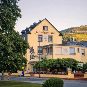 ein großes gelbes Gebäude mit einem Schild darauf in der Unterkunft Hotel Café Post in Rüdesheim am Rhein