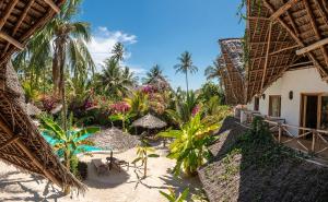 a resort with a beach with chairs and umbrellas at Boutique Villa Unaweza in Matemwe