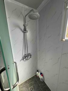 a shower in a bathroom with white marble walls at Cosy Mountain Cabin in Lawson