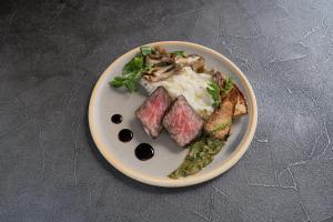 a plate of food with meat and vegetables on a table at BLANC FUJI in Fujiyoshida
