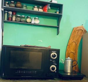 a microwave sitting on a table next to a shelf at La Casa de la Abuela in Paso de los Libres