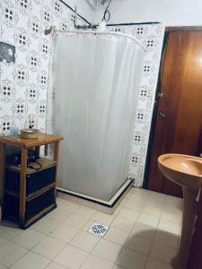 a bathroom with a shower curtain and a sink at La Casa de la Abuela in Paso de los Libres