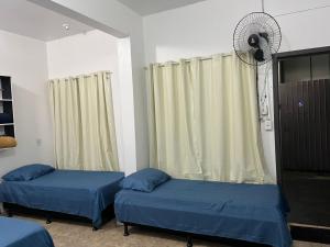 a hospital room with two beds and a fan at Espaço Ideal 2 in Cascavel