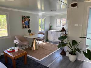 a living room with a table and a kitchen at Cosy Mountain Cabin in Lawson