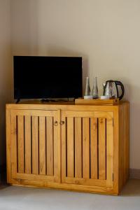 a television on top of a wooden entertainment center at View Merta Ubud Villa in Ubud