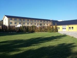 a large building with a large lawn in front of it at Hotel Auto Jas in Nitra