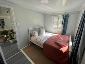 a small bedroom with a bed and a window at Cosy Mountain Cabin in Lawson