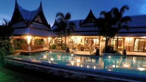 una piscina frente a una casa por la noche en Saifon Villas 5 Bedroom Pool Villa - Whole villa priced by bedrooms occupied, en Ao Nang Beach