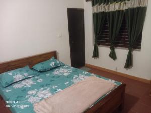 a bedroom with a bed with blue and white sheets at Puthooram Veedu in Chakkarakkal