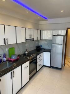 a kitchen with white cabinets and stainless steel appliances at Miloche home in Oulad Akkou
