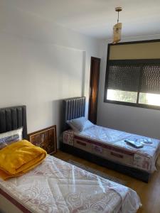 a bedroom with two beds and a mirror on the wall at Miloche home in Oulad Akkou +3 photos