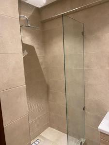 a shower with a glass door in a bathroom at Miloche home in Oulad Akkou