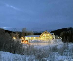a large house in the snow at night at Svenningdal Camping in Svenningdal