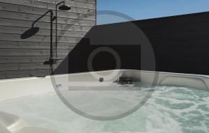 a bath tub filled with water next to a brick wall at Pet Friendly Home In Faaborg With Sauna in Faaborg
