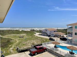 a red truck parked on a balcony next to a beach at Beachgate Condo Suites and Hotel 533 condo in Port Aransas