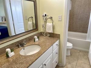 a bathroom with a sink and a toilet and a mirror at Beachgate Condo Suites and Hotel 436 condo in Port Aransas