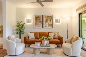 a living room with a couch and two chairs and a table at Let's Get Tropical, Located In The Heart Of Town, 2 King Beds, 2 Pools, 2 Bathrooms in Port Douglas