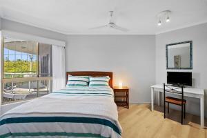 a bedroom with a bed and a desk and a television at Whale Point in Yaroomba +12 photos