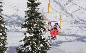 two people riding on a ski lift in the snow at Entire Villa or Rooms! Spacious Villa in Nizepole Hiking, Peace, Private Events in Bitola