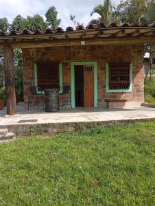 a brick building with a patio with a table and chairs at La Luna cabin in Amagá +7 photos