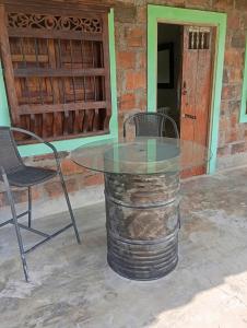 a glass table with two chairs and a table with a barrel at La Luna cabin in Amagá