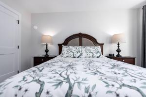 a bedroom with a bed and two lamps on night stands at Cozy Corner on Trumpeter in Colwood
